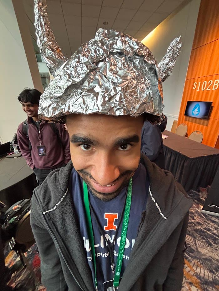 Julius at CypherCon 2025. Wearing a tinfoil hat to protect himself from the CIA